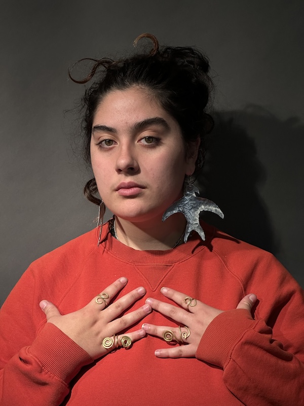Amaya Lounibos Hartard wearing her aluminum bird earrings and set of four finger rings, Fall 2023. amaya-lounibos-hartard-3